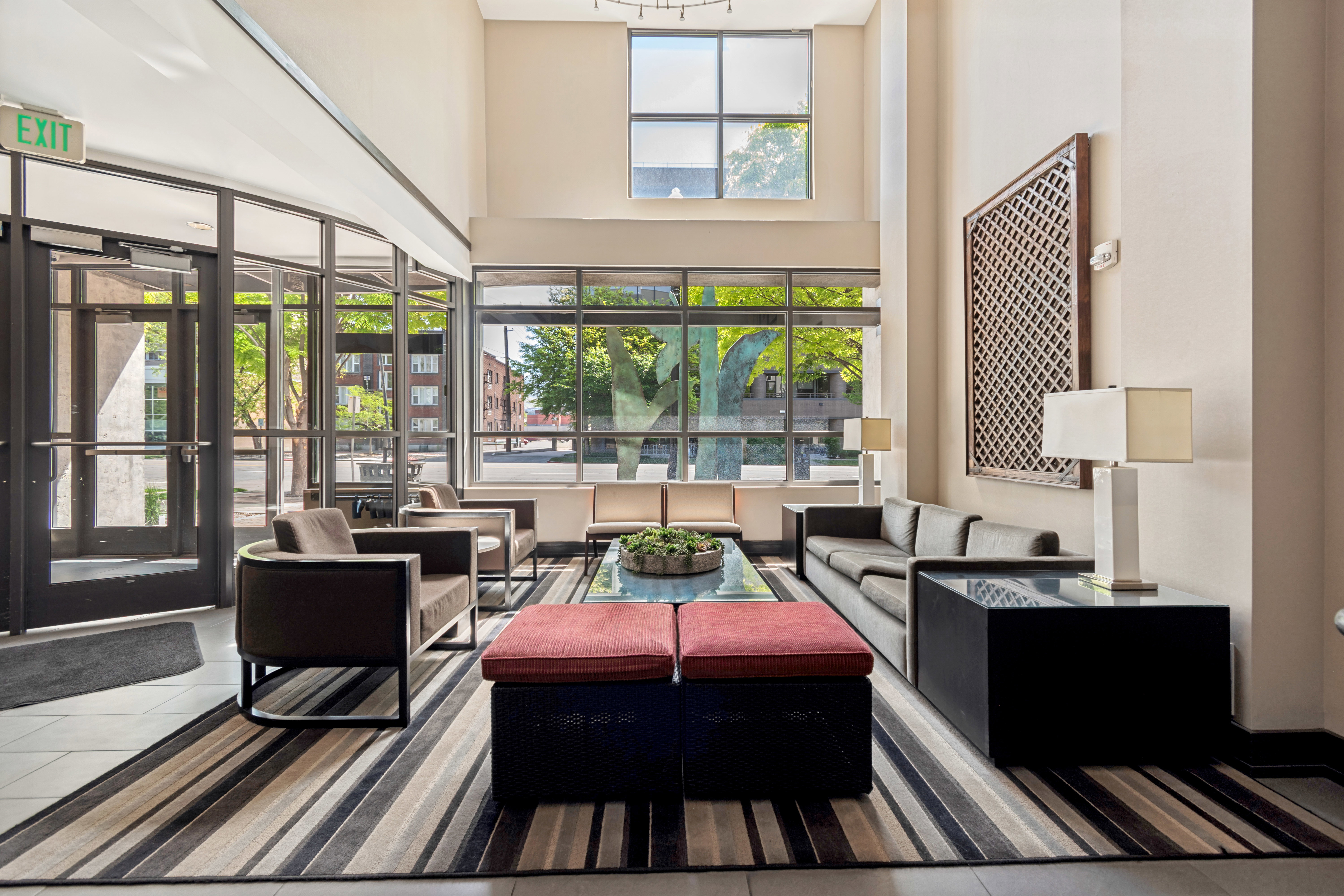 Two-story entry foyer featuring a full wall of windows, high ceilings, tile flooring, and a decorative wall panel