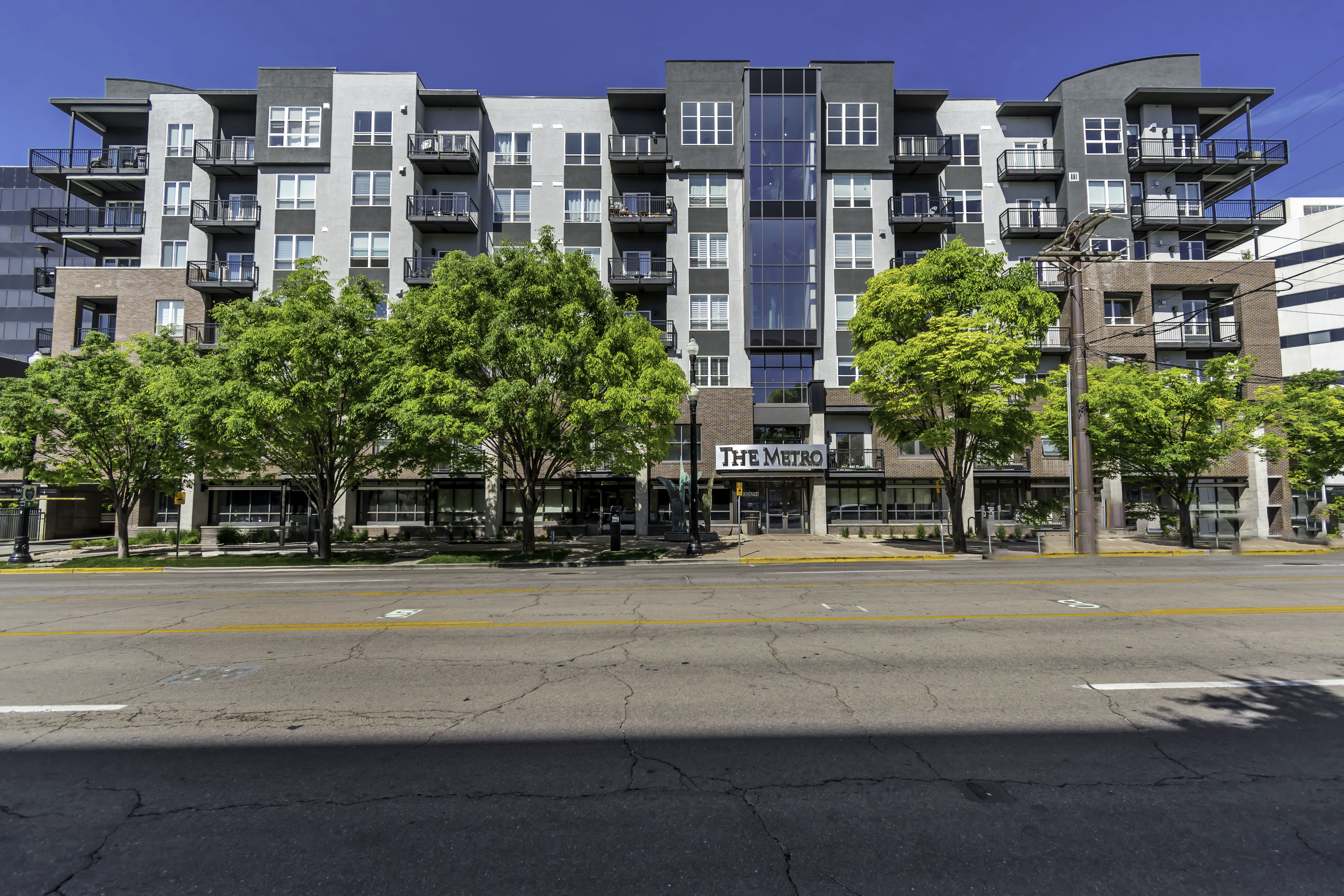 Modern multi-story building featuring brick and paneling on the facade