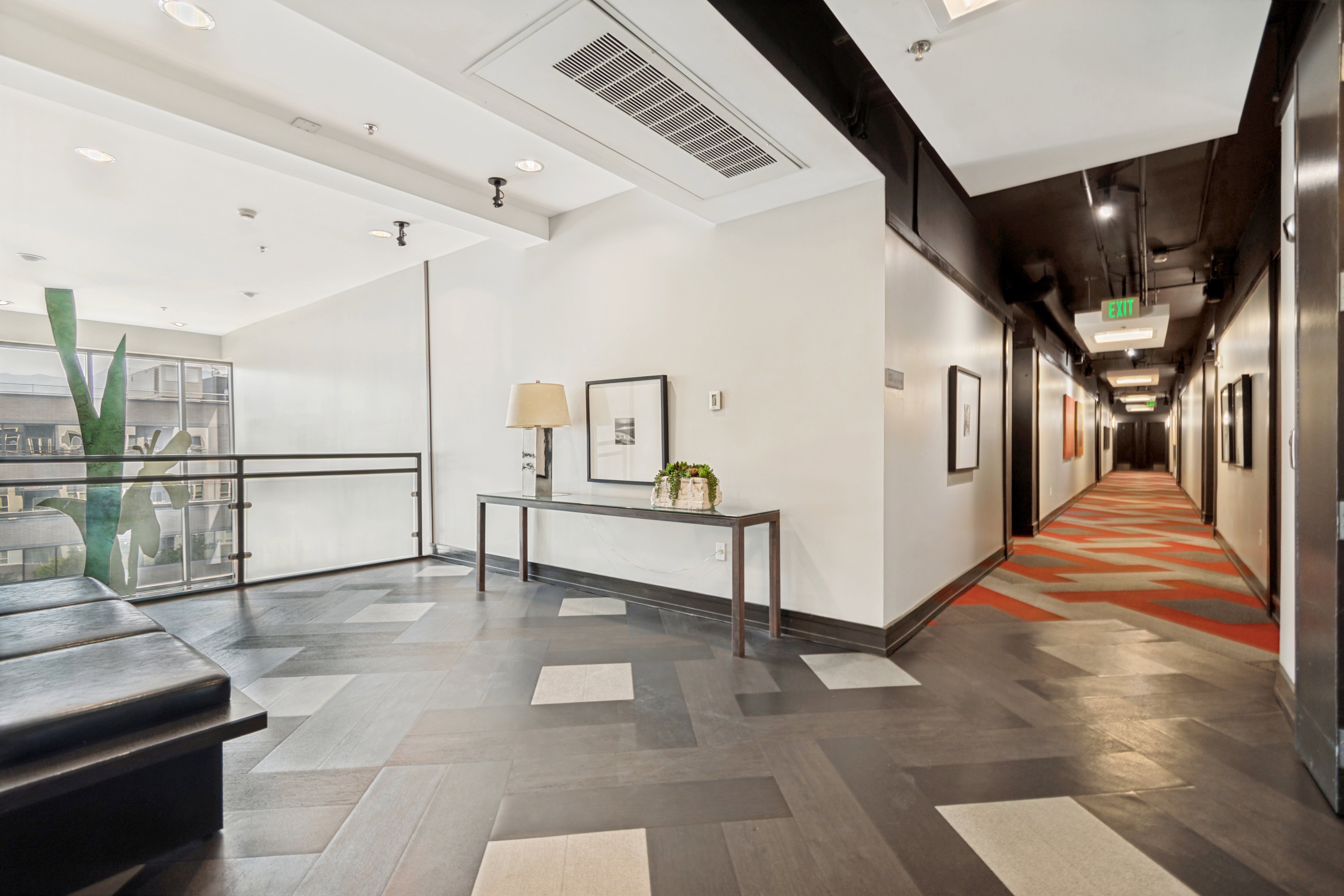 Modern communal hallway featuring wood-finish flooring with light accents