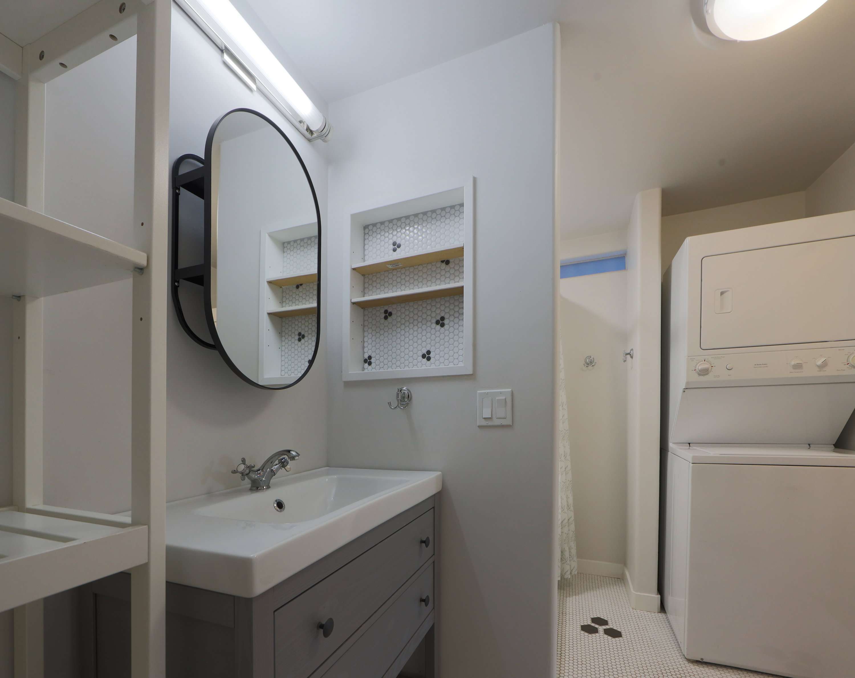 Full bathroom with stacked washer / drying machine, curtained shower, and vanity