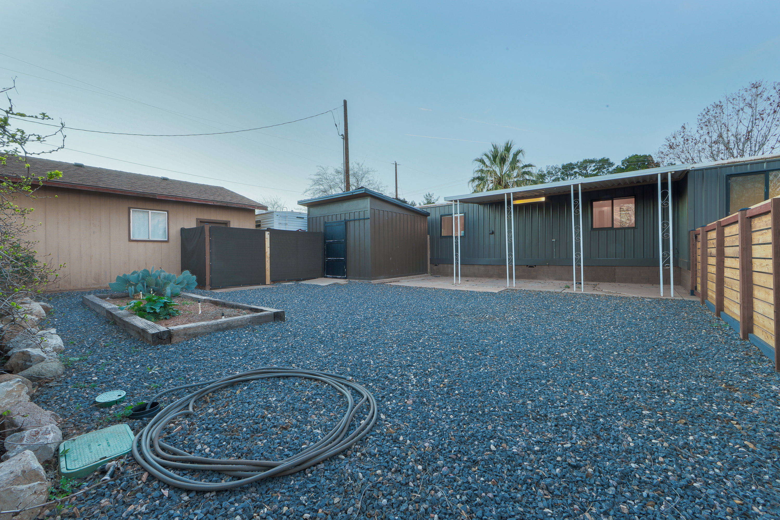 Rear view of property featuring a fenced backyard, a vegetable garden, and an outdoor structure