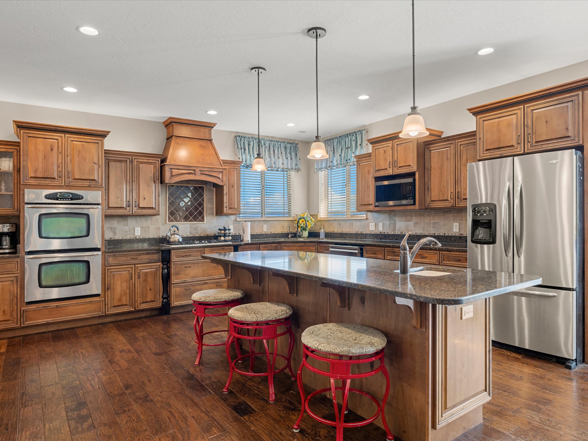Kitchen featuring wood-finish cabinetry, granite countertops, and wood-finish flooring