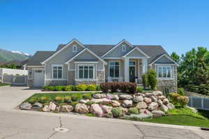 Contemporary ranch-style residence featuring a combination of light gray siding and stone facade