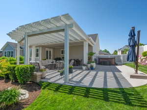 Expansive concrete patio featuring a white pergola structure