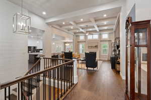 Hardwood flooring throughout featuring a staircase with wood handrails and black metal balusters