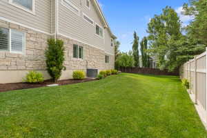 Expansive grass lawn with a light-colored privacy fence