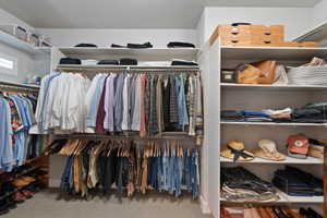 Primary suite Custom closet system featuring extensive shelving, multiple hanging rods, and integrated shoe storage