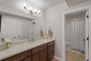 Bathroom vanity with an integrated rectangular sink, stone-finish countertop, and brushed nickel hardware