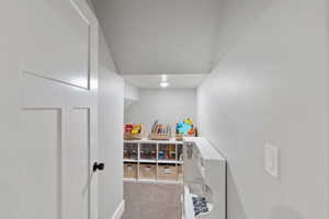 Perfect play area to store toys, recessed lighting illuminates a carpeted alcove with built-in shelving, offering integrated storage solutions