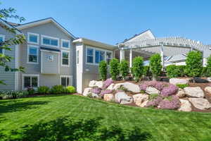Expansive green lawn with a tiered rock garden featuring mature shrubs and groundcover
