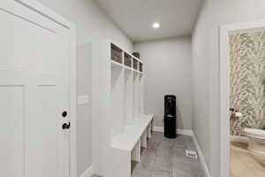 Entryway featuring a built-in bench with cubbies, light gray wall paint, and tile flooring