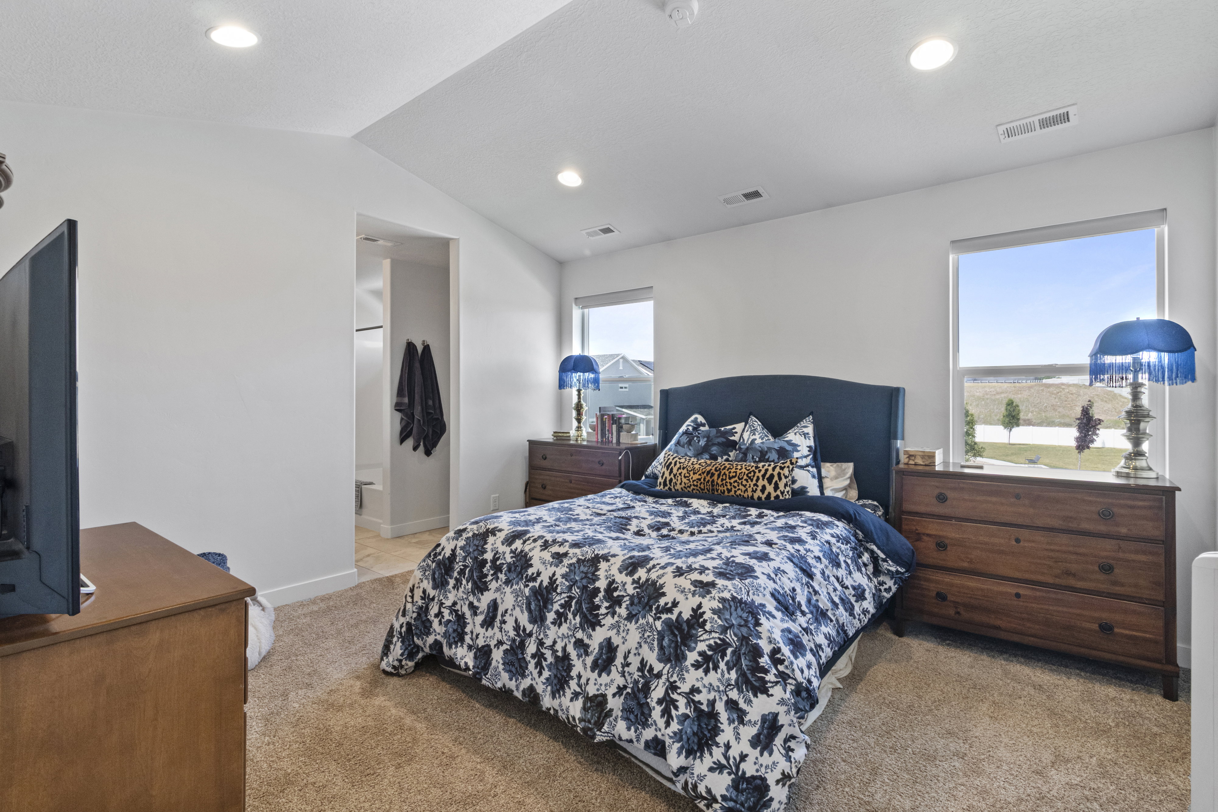 Carpeted room featuring a vaulted ceiling with recessed lighting