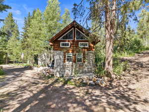 Rustic cabin exterior featuring a stone and wood siding combination