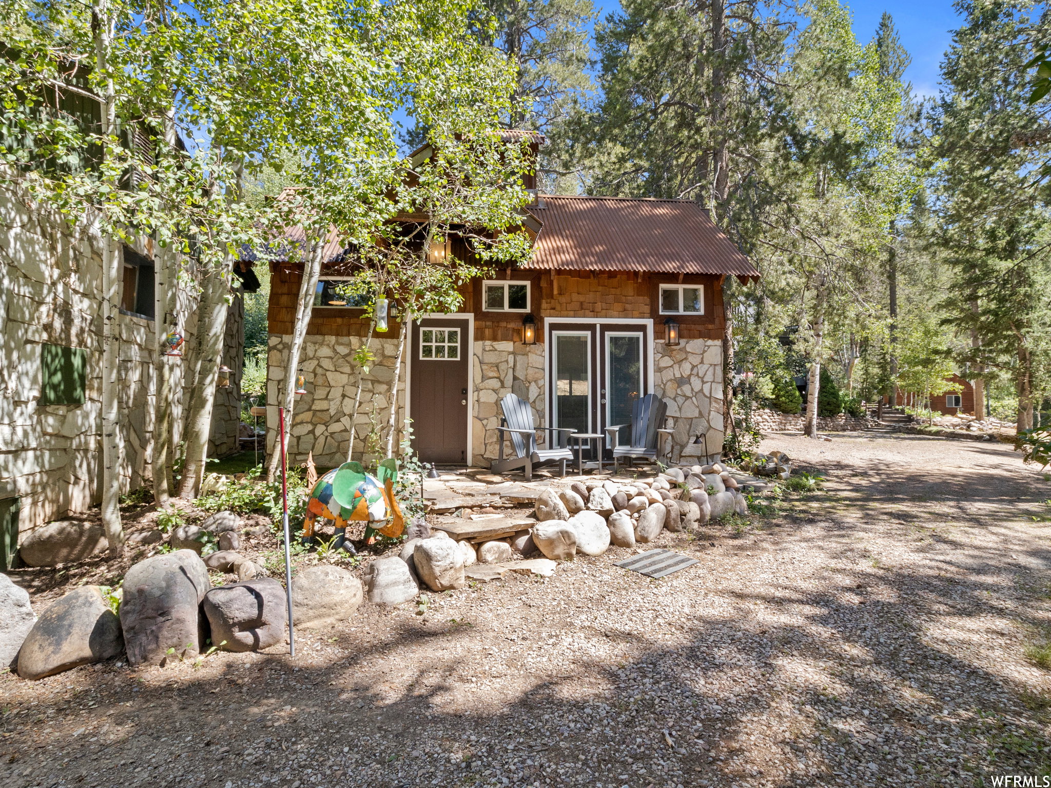 Stone and wood-sided cottage with a corrugated metal roof