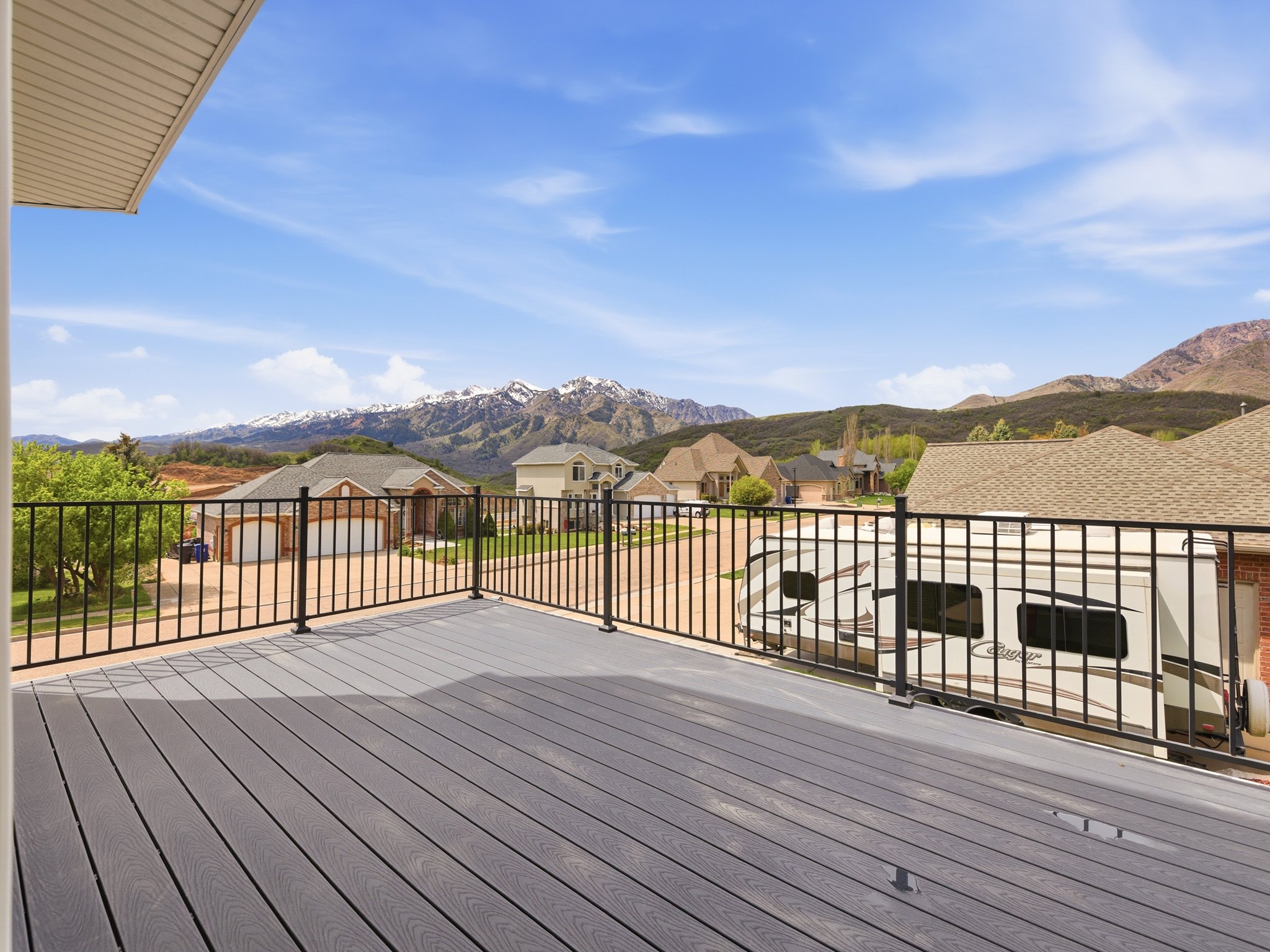 Spacious outdoor deck with composite decking and black metal railings, offering expansive mountain scenery