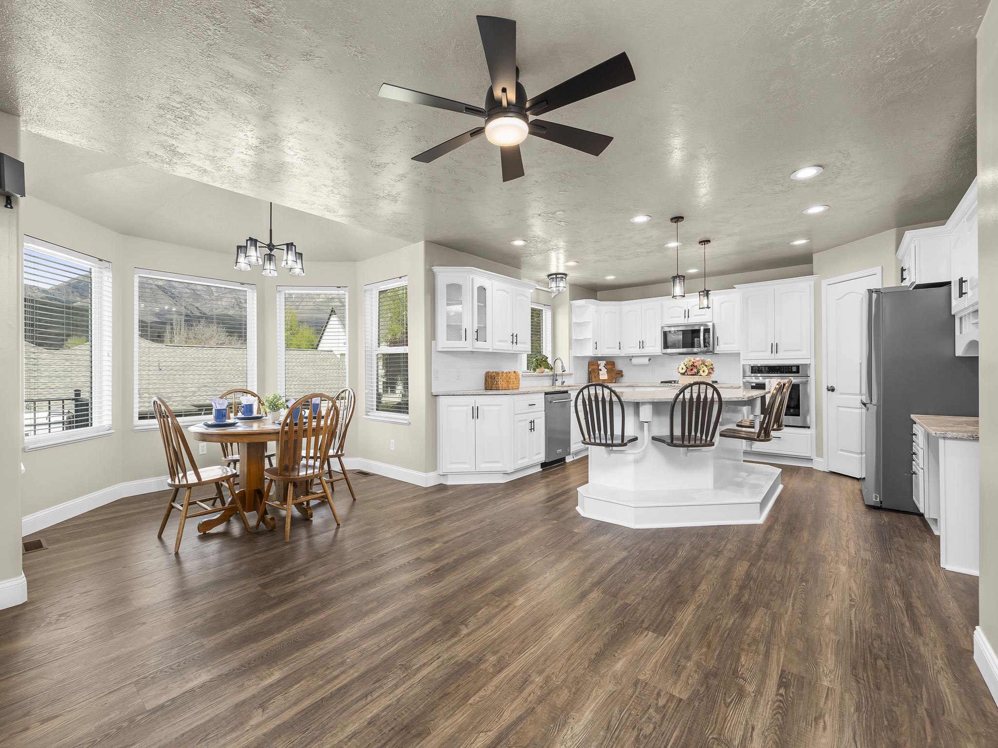 Open-concept living space featuring wood-finish flooring, a contemporary ceiling fan, and recessed lighting