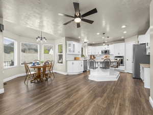 Open-concept living space featuring wood-finish flooring, a contemporary ceiling fan, and recessed lighting