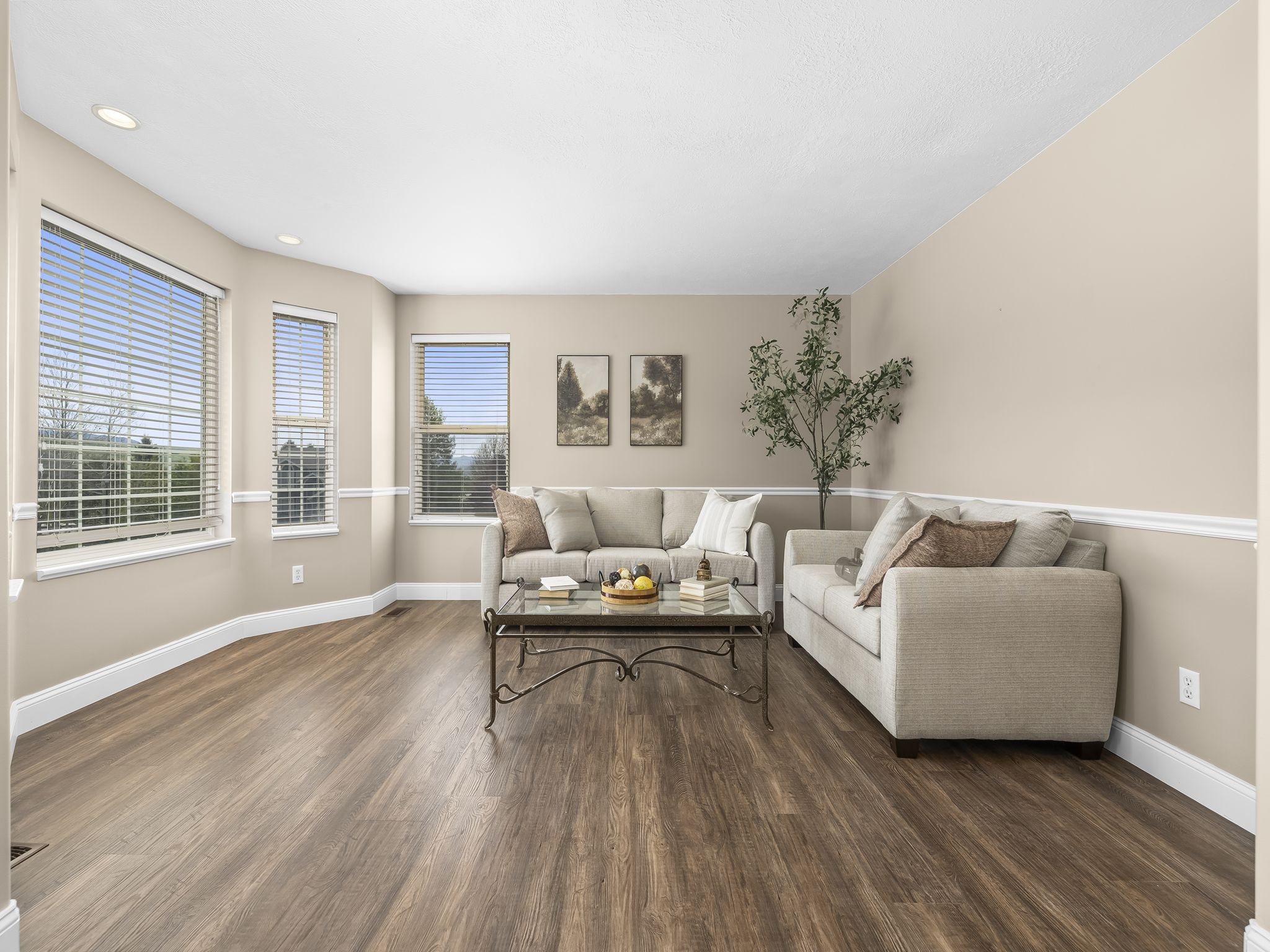 Spacious living area featuring wood-finish flooring, recessed lighting, and a chair rail molding