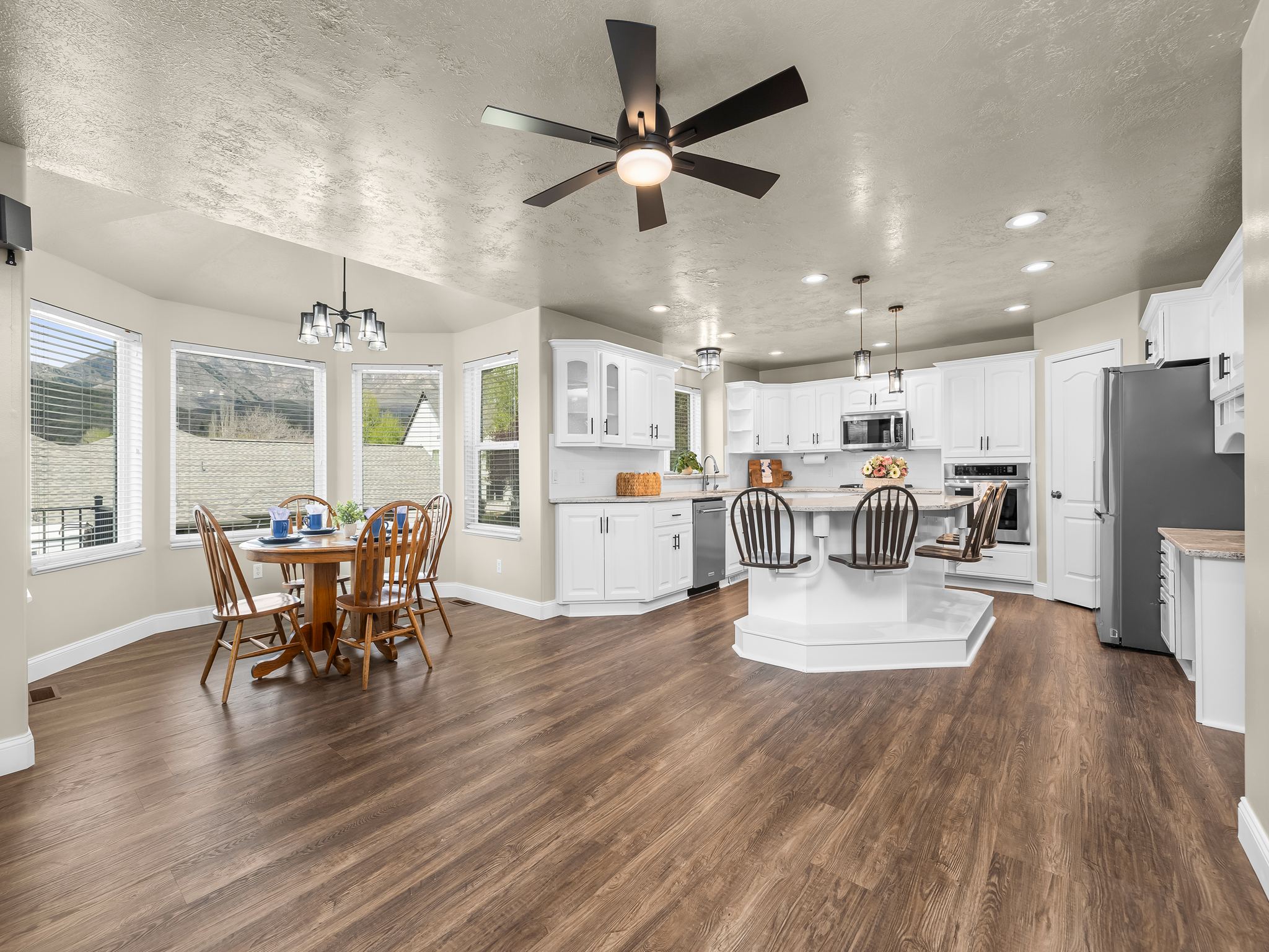 Open-concept living space featuring wood-finish flooring and a contemporary ceiling fan