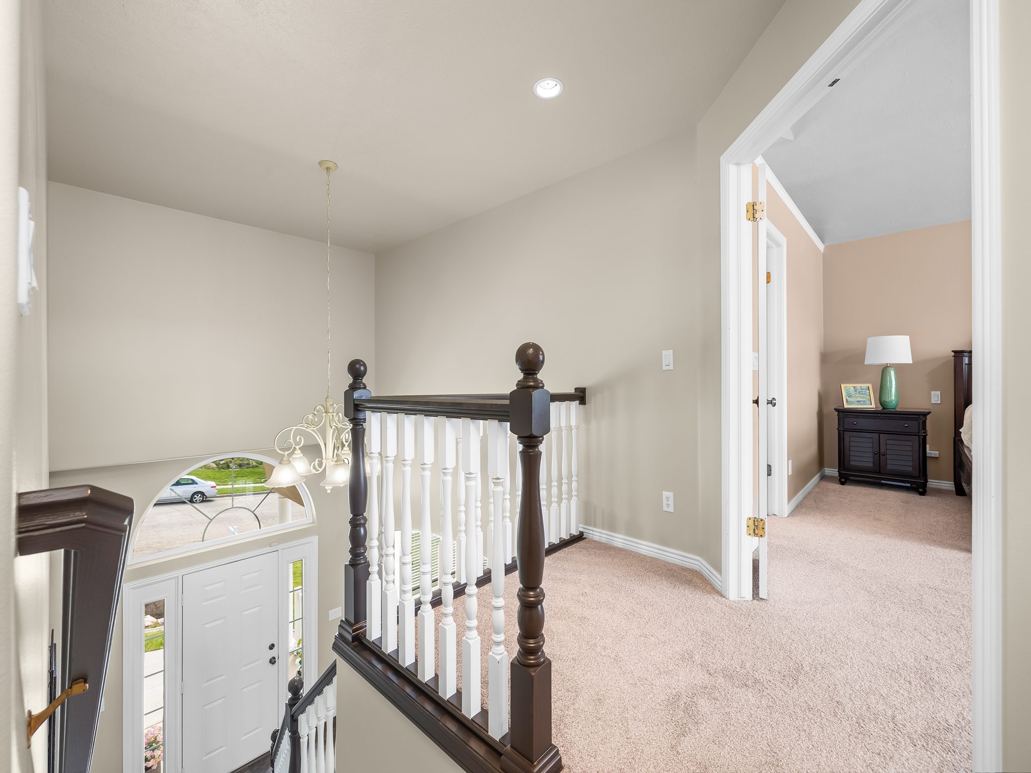 Split-level entryway featuring a white paneled door with sidelights and an arched transom window