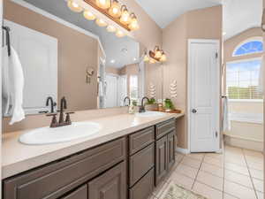Double vanity with integrated sinks and bronze-finish faucets set against a full-width mirror