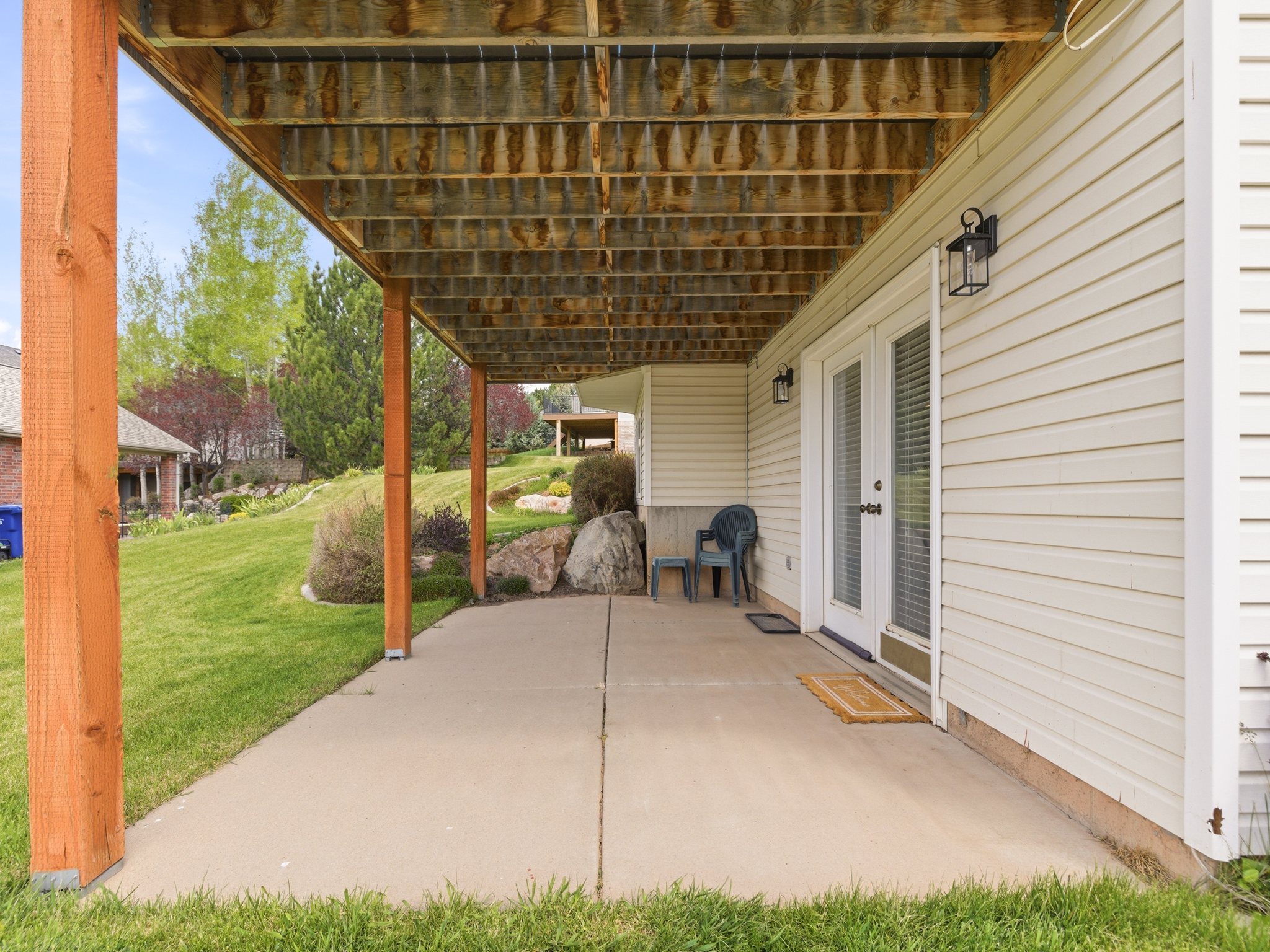 Covered concrete patio with wooden support columns
