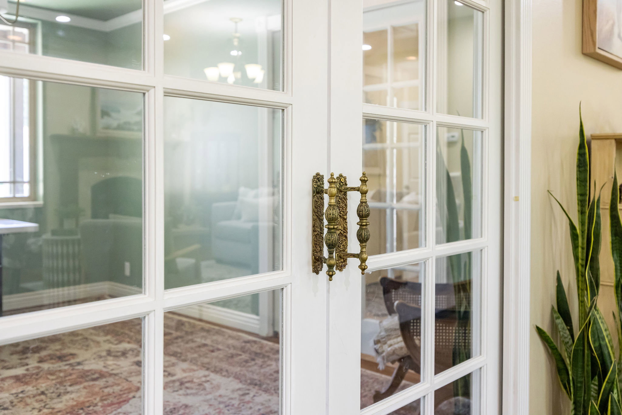 French doors with clear glass panes and an ornate brass handle