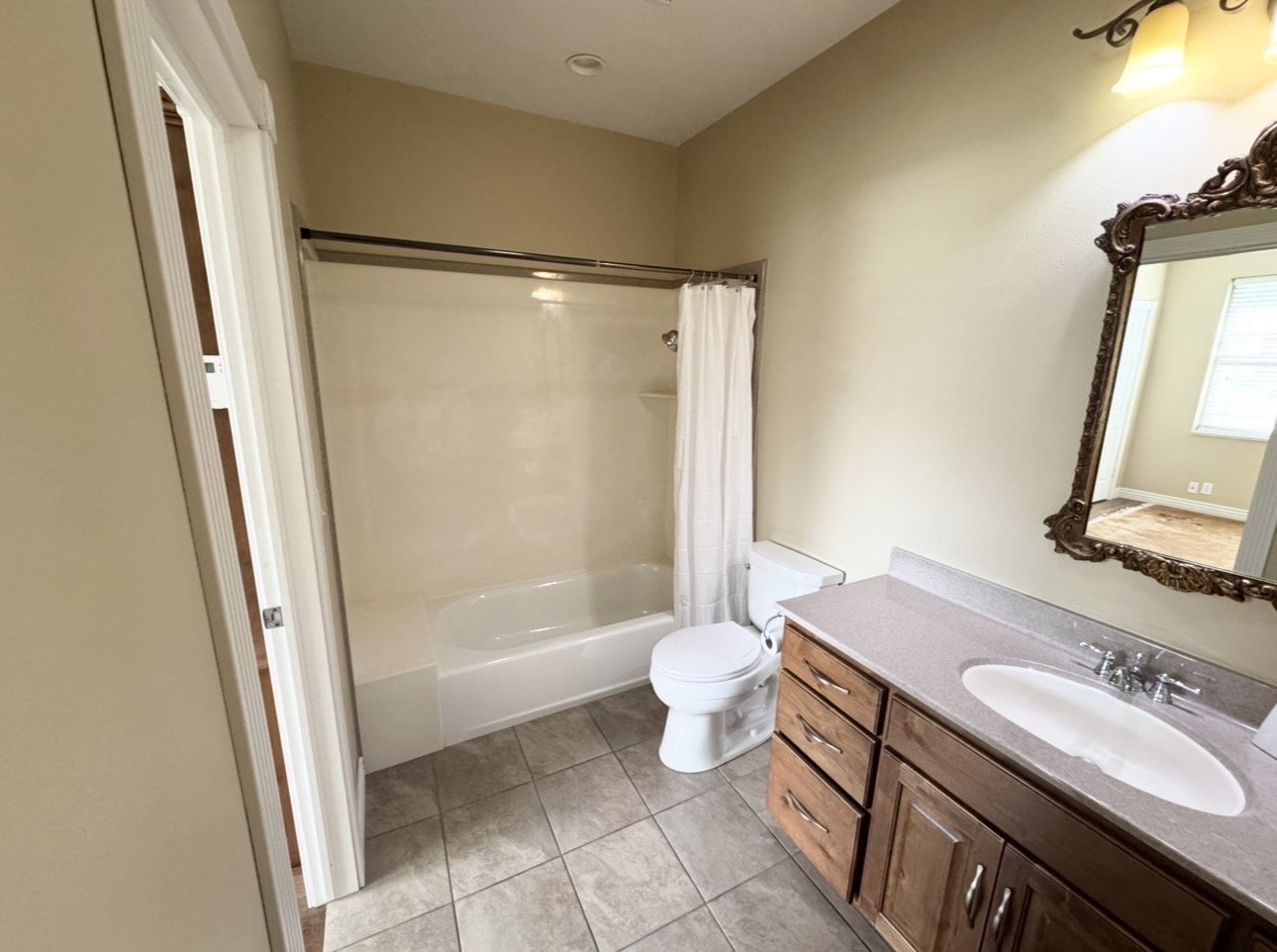 Bathroom featuring a single vanity with wood-finish cabinetry, a light-colored countertop, and a recessed sink