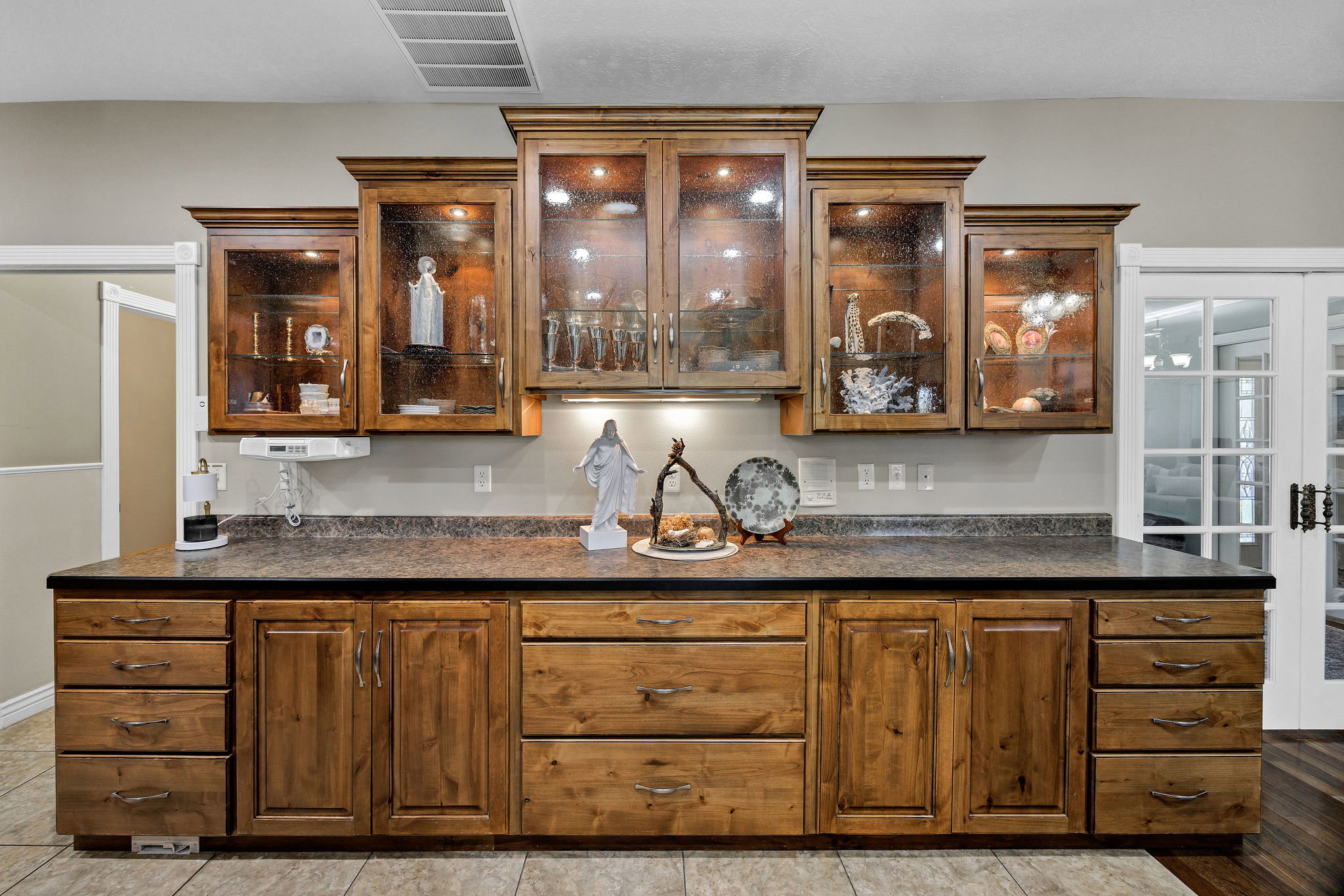 Custom wood cabinetry featuring glass-front uppers and under-cabinet lighting