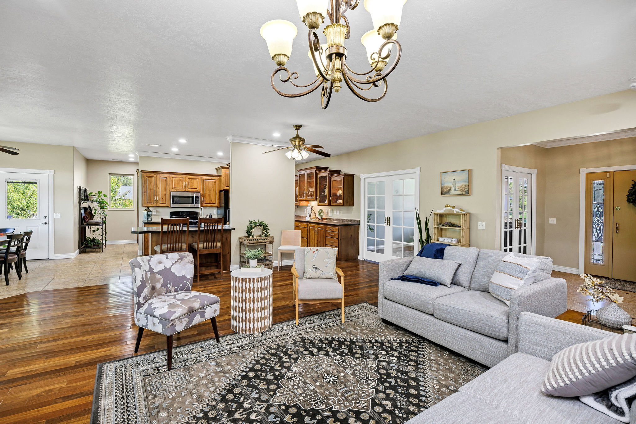 Spacious living area featuring wood-finish flooring, a decorative chandelier, and an open concept layout