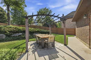 Outdoor living space featuring a pergola with string lights, a flagstone patio, and a dining table