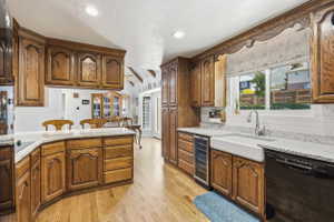 Kitchen featuring wood-finish cabinetry, light-toned countertops, and wood-finish flooring