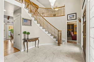 Grand entryway featuring a curved staircase with wood railings and carpeted treads