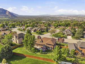 Expansive residential area featuring numerous single-family homes with mature trees and visible mountain ranges in the distance