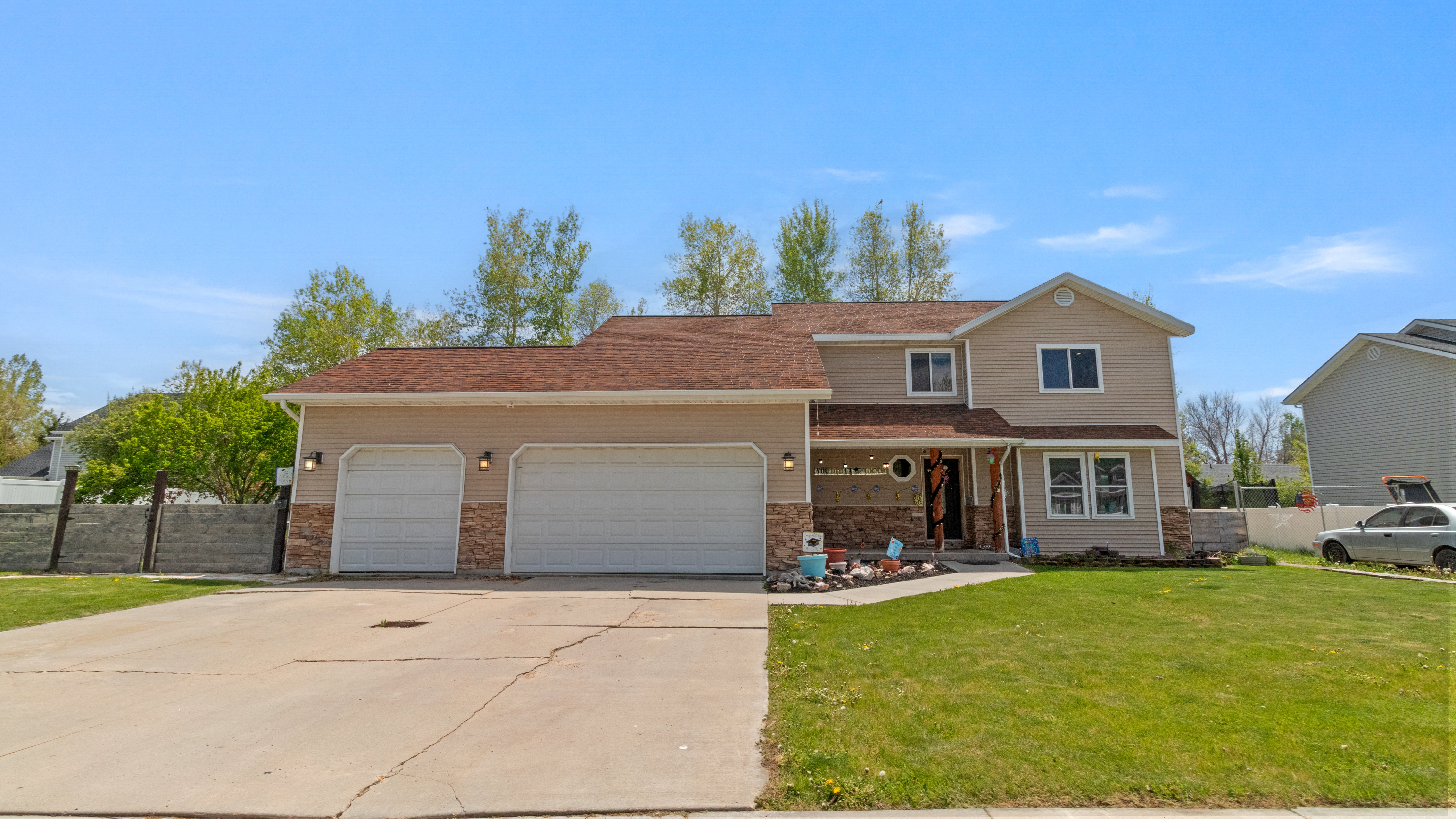 Two-story residence with a two-car garage, stone facade accents, and a covered front porch