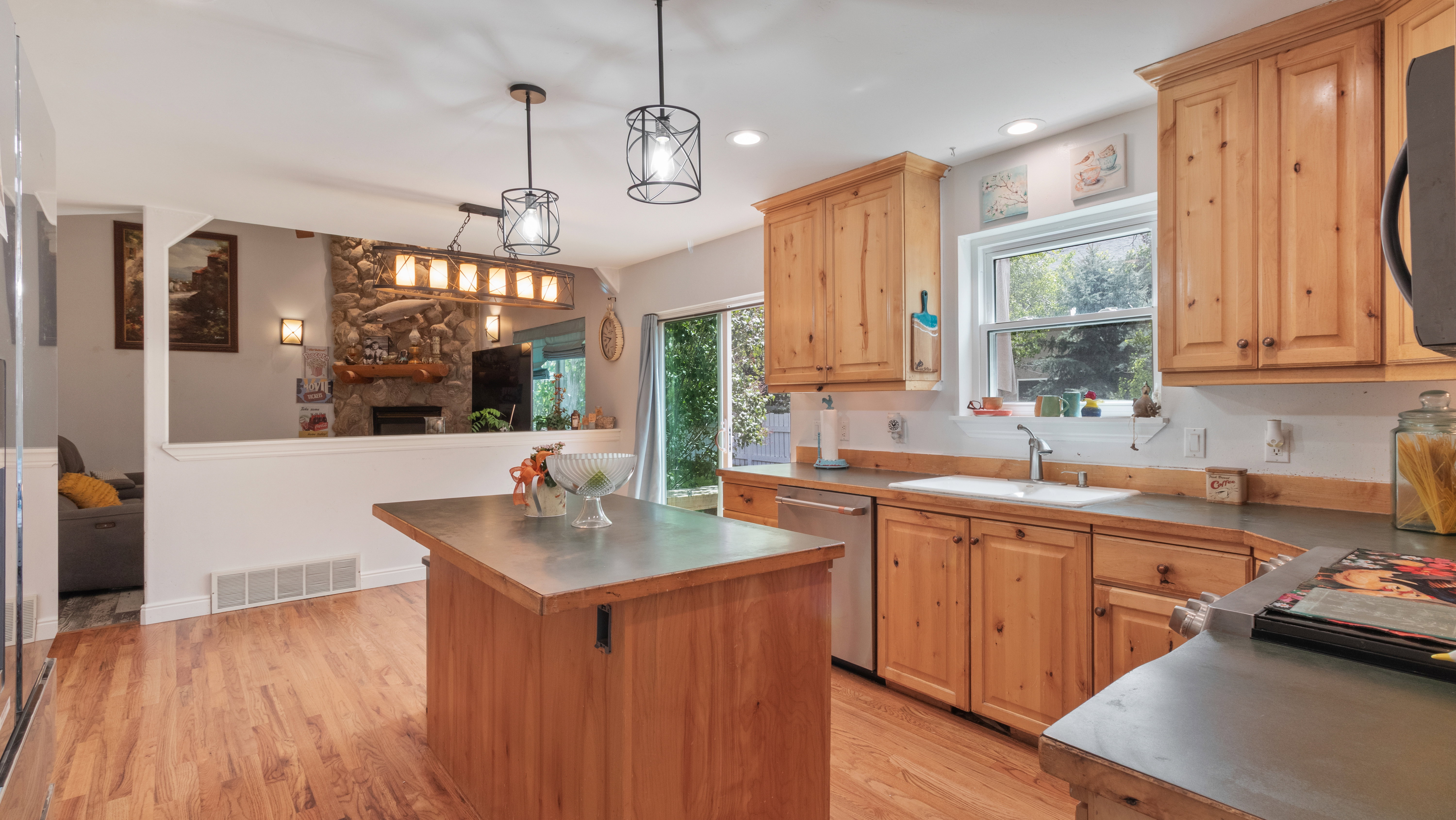 Kitchen featuring wood-finish flooring, natural wood cabinetry, a central island, stainless steel appliances, and recessed lighting