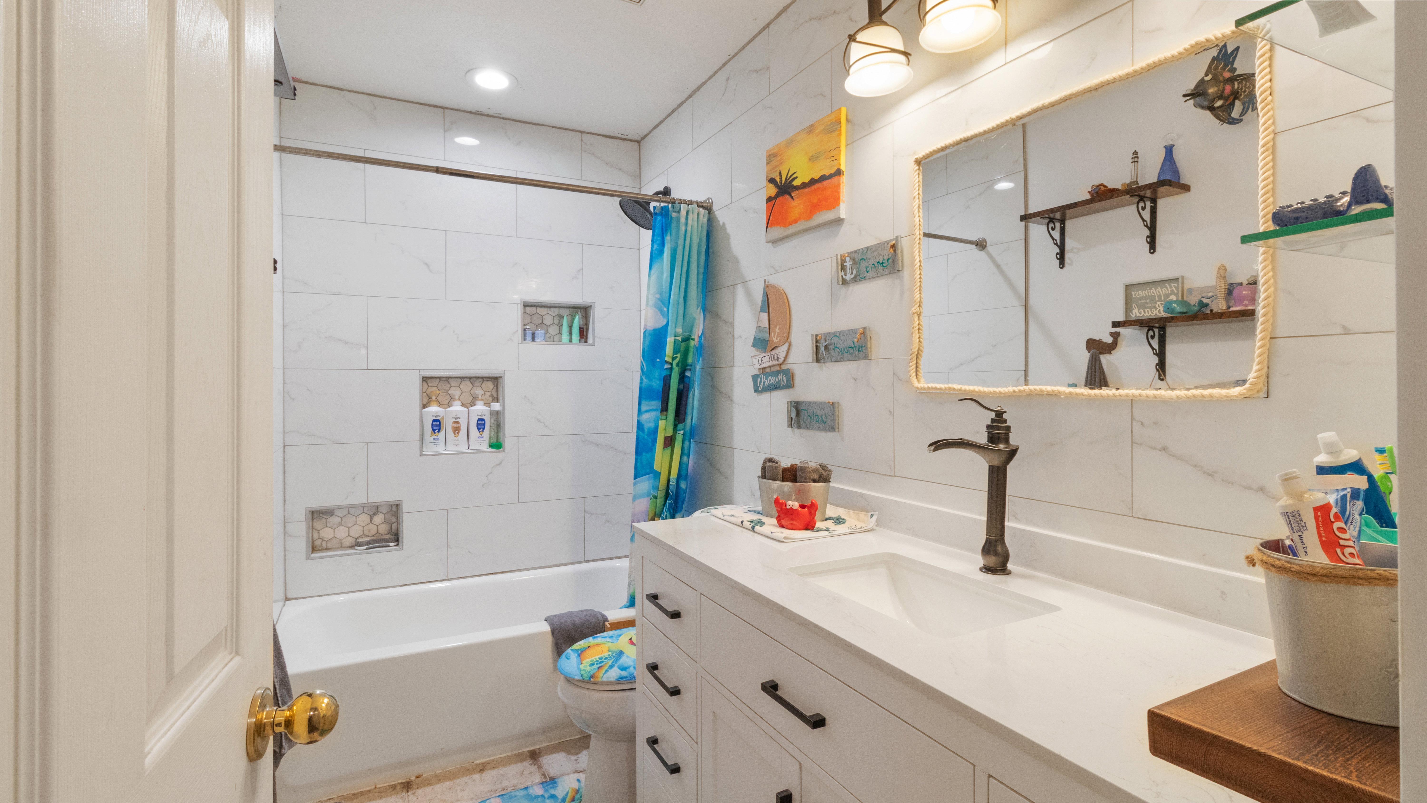 Bathroom featuring a vanity with an integrated sink, a white countertop, and dark bronze hardware