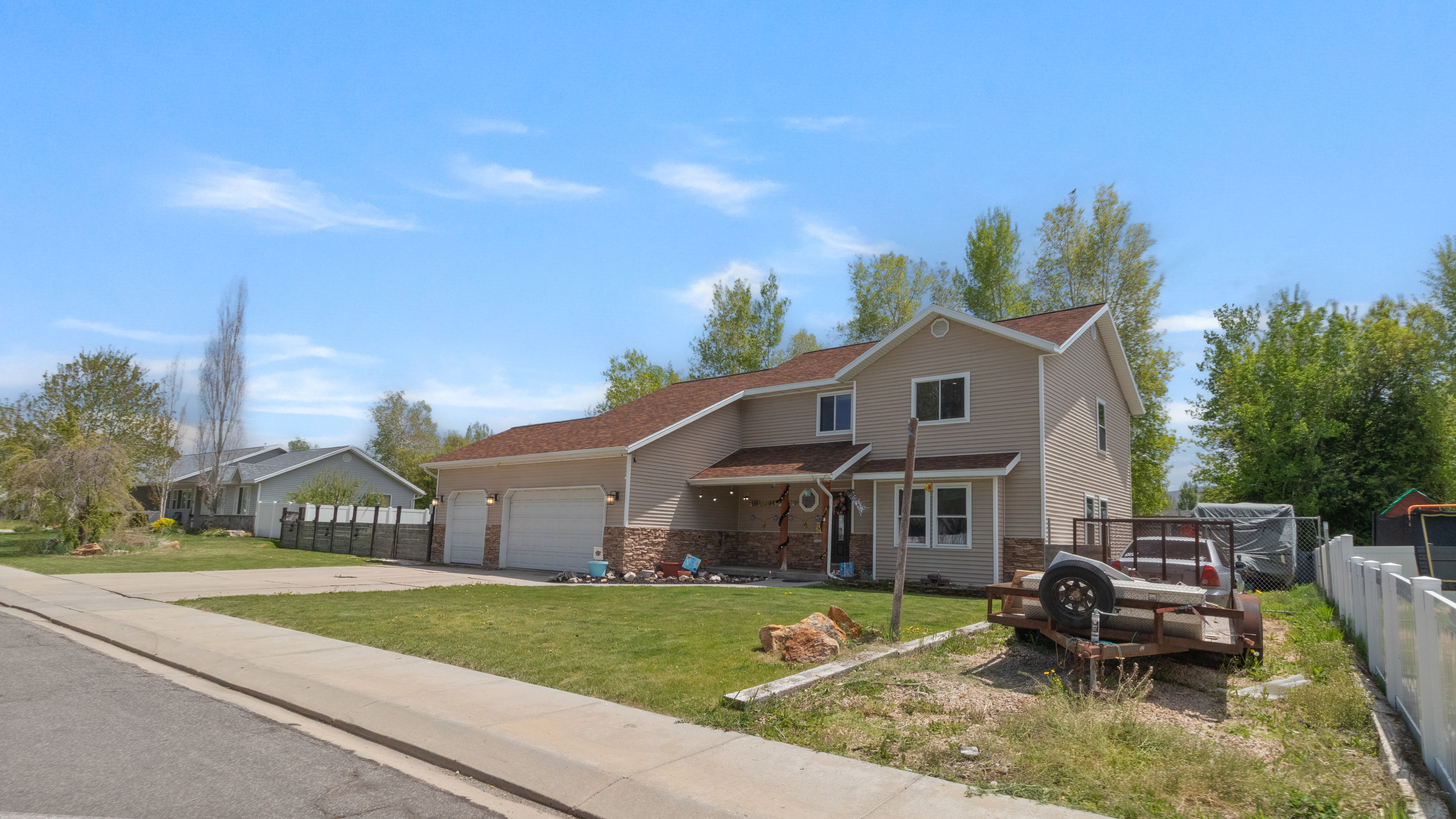 Two-story residence featuring light beige siding and a brown shingle roof