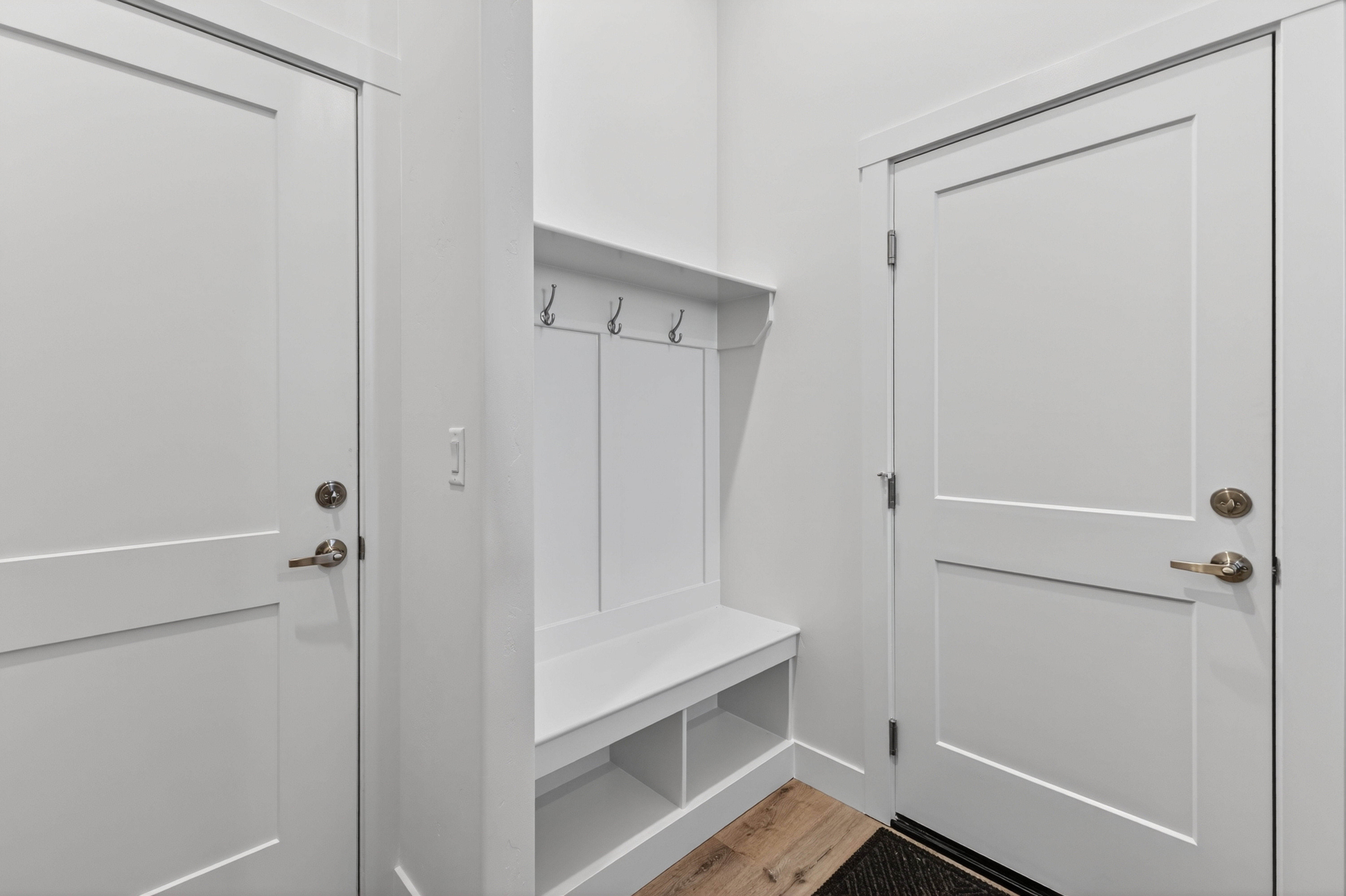 Built-in mudroom bench with shelving, coat hooks, and overhead storage