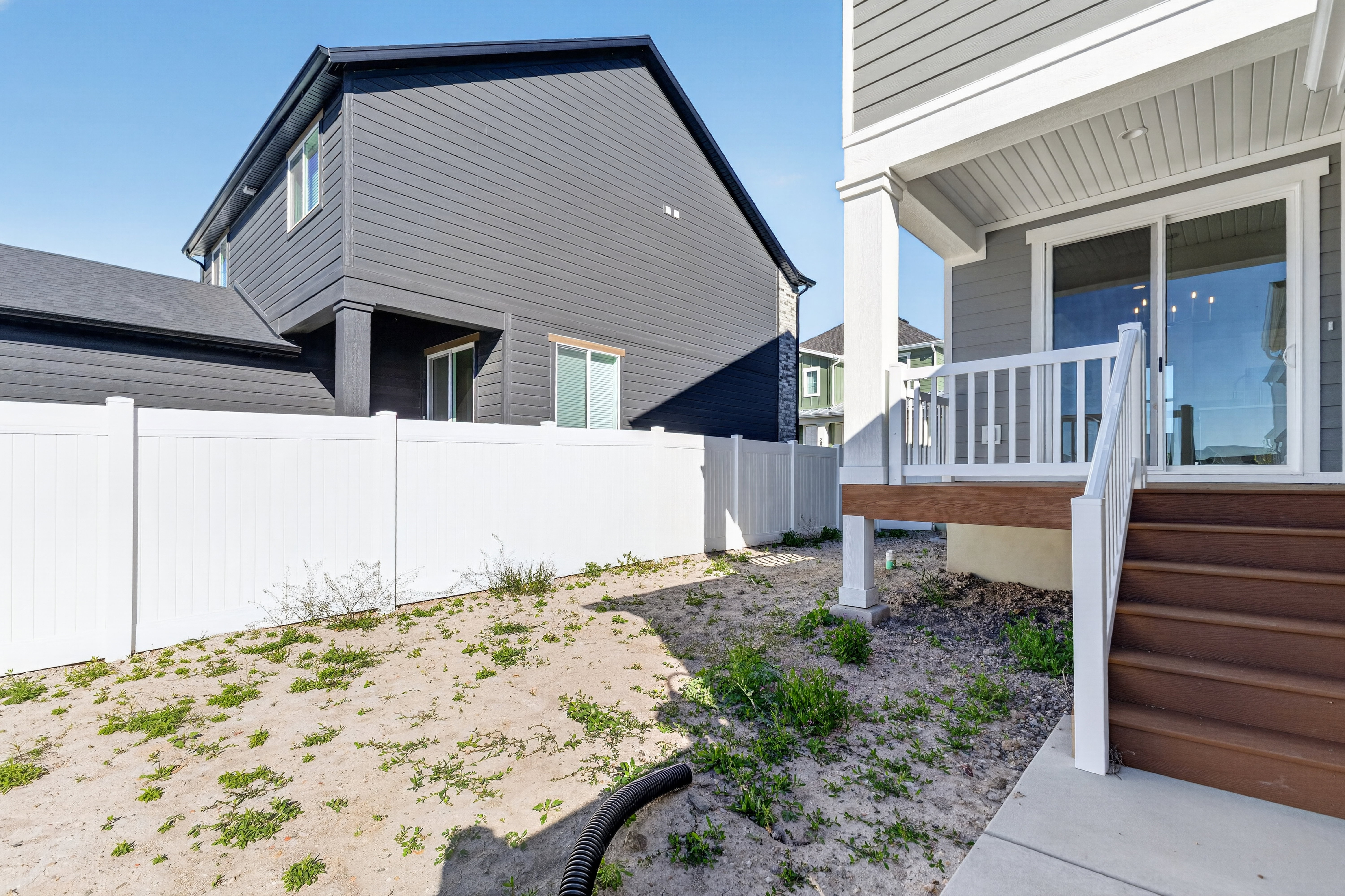 Rear exterior featuring a privacy fence, contemporary siding, and a deck with stairs