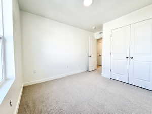 Carpeted interior space featuring white walls and trim
