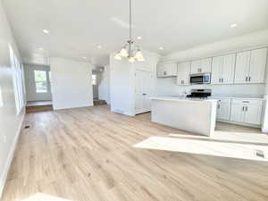 Open-concept living space featuring wood-finish flooring, recessed lighting, and a modern kitchen