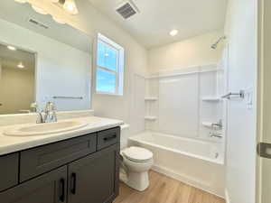 Bathroom with a dark gray vanity, light countertop with an integrated sink, and chrome fixtures