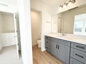 Bathroom vanity with a light-toned countertop, integrated sink, and gray cabinetry featuring black hardware