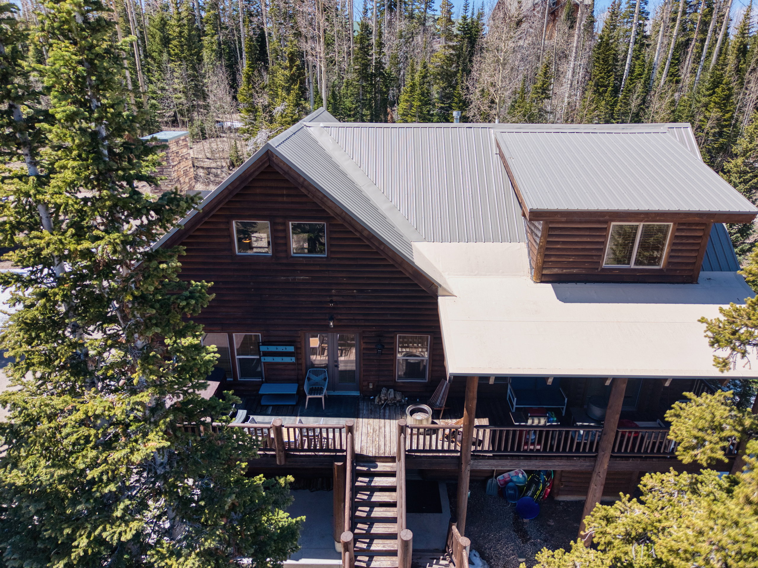Log cabin exterior featuring a metal roof and an elevated wood deck