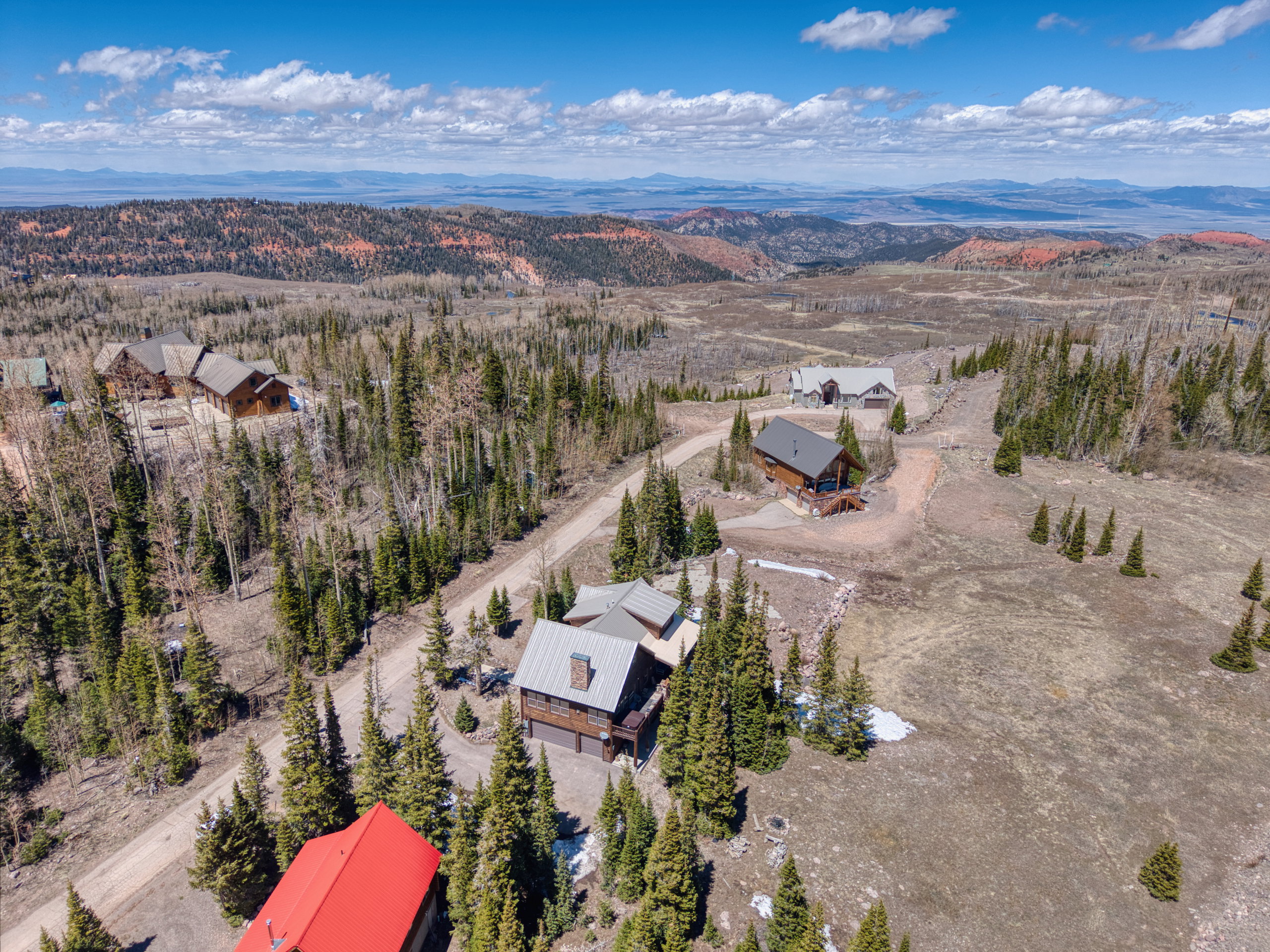 Aerial perspective showcasing multiple mountain residences amidst a dense forest landscape