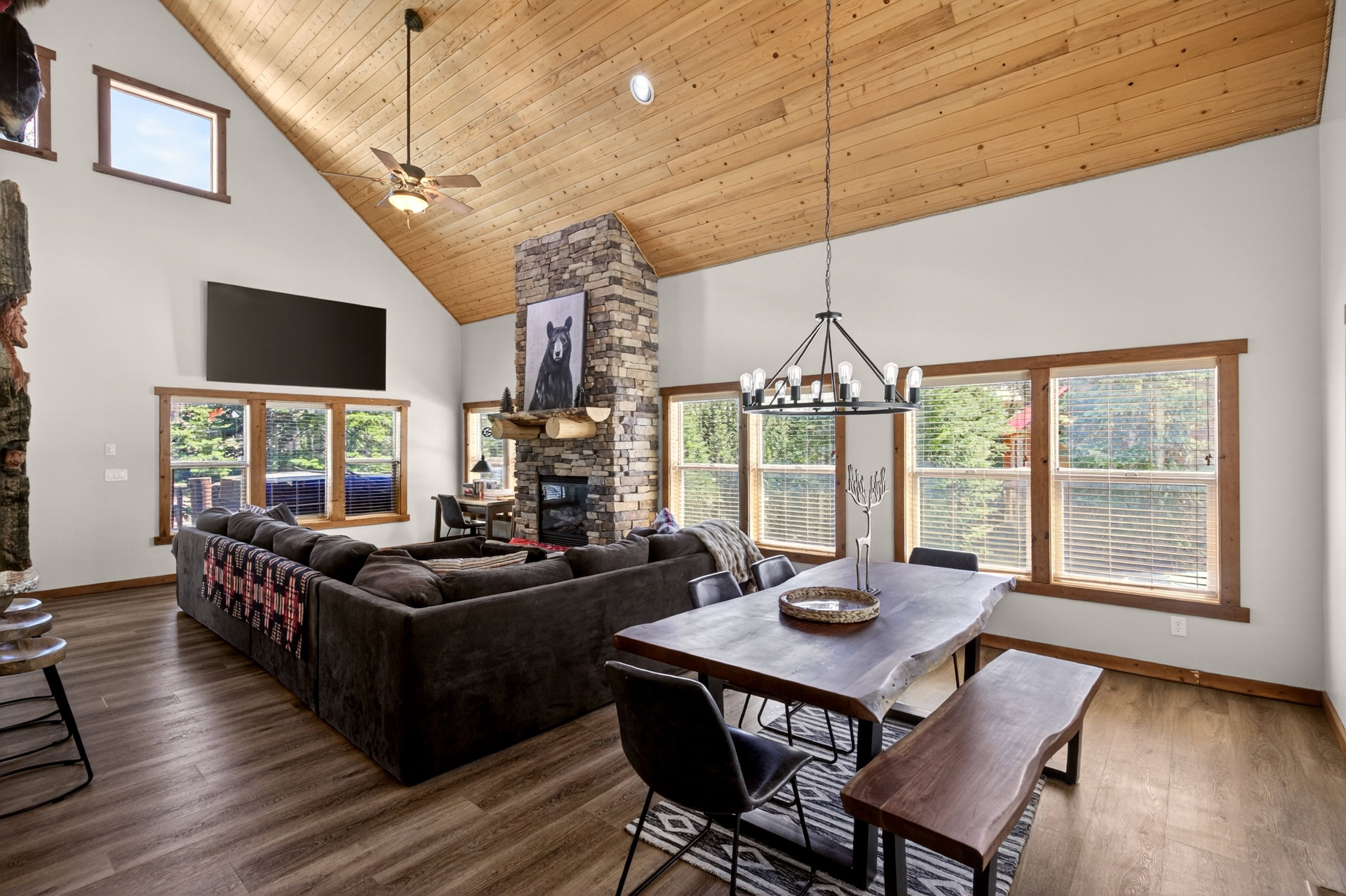 Vaulted wood-paneled ceiling with exposed beams, complemented by a floor-to-ceiling stone fireplace