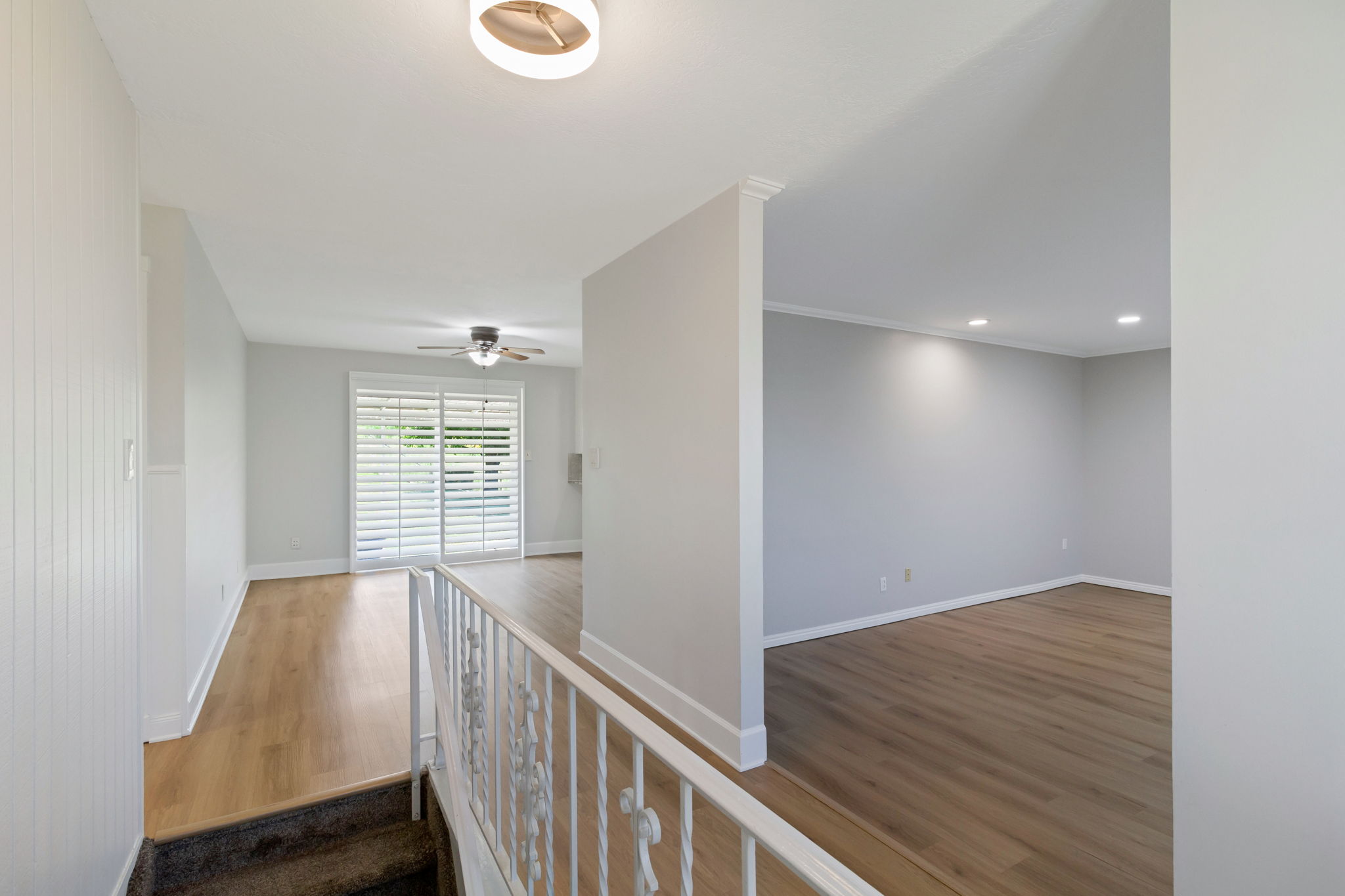 Interior featuring wood-look flooring, white plantation shutters, a ceiling fan, recessed lighting, and a contemporary ceiling fixture