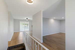 Interior featuring wood-look flooring, white plantation shutters, a ceiling fan, recessed lighting, and a contemporary ceiling fixture