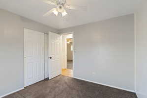 Carpeted room with a ceiling fan light fixture, white six-panel bifold closet doors, and light gray painted walls